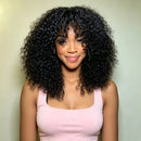 A woman with voluminous, curly black hair wearing a light pink ribbed tank top, standing against a solid pale sage green background, Obroi