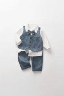 A baby boy's three-piece formal outfit featuring a blue-gray plaid vest with a matching plaid bow tie, a white long-sleeve collared shirt, and matching plaid trousers, laid flat on a white background, Obroi
