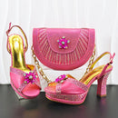 Pink high-heeled shoes with gold accents and a matching pink handbag on a white background, Obroi