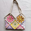 Crocheted bag with colorful flower patterns on a light gray background, Obroi
