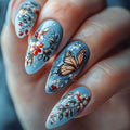 Nails with floral and butterfly design on a light blue background, Obroi