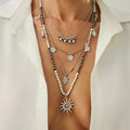 Necklace with sun pendant and beaded design on a white shirt background, Obroi