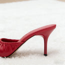 Red high-heeled shoe on a white surface, Obroi