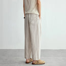 Person wearing beige sleeveless top and wide-leg pants on a plain background, Obroi