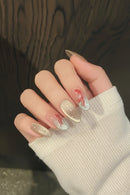 Close-up of a hand with decorative nail art featuring red and silver designs, Obroi
