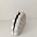 White ceramic lip-shaped vase with black interior on a light gray background, Obroi