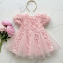 Pink floral dress with a headband and flowers on a marble surface, Obroi