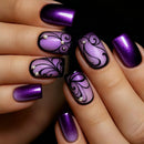 Close-up of a hand with purple and black nail art on a dark background, Obroi