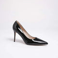 A single black patent leather pointed-toe pump with a slim stiletto heel, shown from a side profile on a clean white background, Obroi