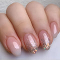 Close-up of a hand with pink and glittery nails on a light background, Obroi