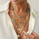 Necklace with green and gold beads and pearls on a white background, Obroi