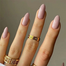 Close-up of a hand with pink nail polish and gold rings on a neutral background, Obroi