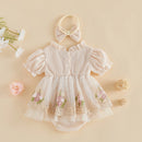A baby girl's cream-colored waffle-knit romper with a matching bow headband, styled in a flat lay with decorative flowers and woven balls on a beige background, Obroi