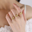 Gold floral ring on a hand with a blurred background, Obroi