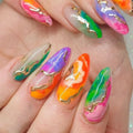 Multicolored nail art with gold accents on a hand, Obroi