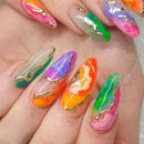 Multicolored nail art with gold accents on a hand, Obroi