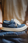 Blue denim sneaker with white sole worn by a person sitting on a chair, Obroi