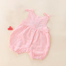 Pink baby romper on a beige background with a red clip, Obroi