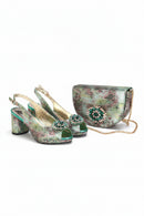 Pair of green high-heeled shoes with embellishments and a matching handbag on a white background, featuring the brand 'Obroi'.