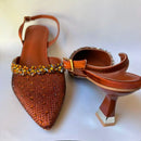 Brown high-heeled shoes with embellishments on a white background, Obroi
