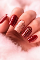Nails with red and gold design on a soft pink background, Obroi