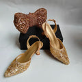 Gold glittery shoes and matching handbag on a white background, Obroi