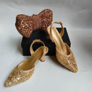 Gold glittery shoes and matching handbag on a white background, Obroi