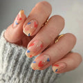 Close-up of a hand with colorful nail art on a neutral background, Obroi