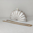 Shell-shaped clutch with a gold chain on a light background, Obroi