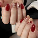 Close-up of hands with red and gold floral nail design, Obroi