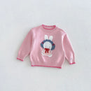 A pink knit baby sweater featuring a knitted bunny graphic on the chest with white ears, a blue floral wreath, and a red bow, displayed flat against a light gray background, Obroi