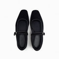 Pair of black flat shoes with a strap on a white background, Obroi