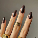 Hand with dark nail polish and gold rings on a neutral background, Obroi