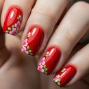 Close-up of a hand with red nail polish and floral designs, Obroi