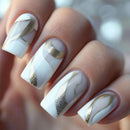 Nails with white and gold design on a blurred background, Obroi