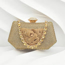 A gold mesh clutch handbag with a large 3D flower detail on the front, a gold chain strap, and a gold clasp, set against a white background with soft shadows, Obroi
