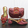 Red high-heeled shoes and matching handbag with gemstone details on a dark surface, Obroi