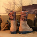 Pair of brown leather boots with buckles on a wooden surface, Obroi