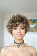 Woman with styled hair and a necklace in a neutral setting, Obroi