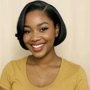Woman with a short black bob hairstyle wearing a yellow shirt against a beige background, Obroi