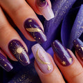 Nails with purple and gold designs, including moons, stars, and suns, against a matching background, Obroi
