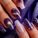 Nails with purple and gold designs, including moons, stars, and suns, against a matching background, Obroi
