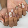 Obroi Close-up of hands with decorative nail art on a neutral background