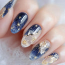 Nails with starry night design featuring blue, white, and gold colors, Obroi