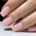 Close-up of a hand with pink nail polish on a neutral background, Obroi