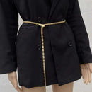 Black coat with a gold belt on a mannequin against a light background, Obroi