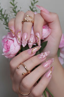 Close-up of hands with pink and gold nail art and matching rings, Obroi