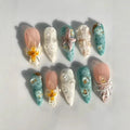 Decorative nail art with seashells, flowers, and starfish on a light , Obroi