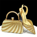 Gold handbag and high-heeled shoe with intricate designs on a white background, Obroi