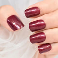 Close-up of a hand with burgundy nail polish on a light background, Obroi